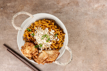 Mie Goreng ala Mie Gacoan is homemade fried noodle topping with chicken shraded and fried dumpling.