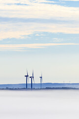Fog in a rolling landscape with wind turbines