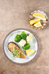 Fried salmon steaks with lemon butter sauce garnish with micro greens.