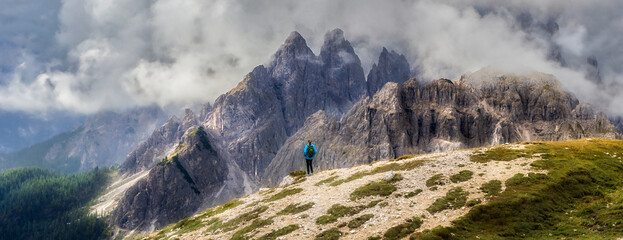 Travel and tourism concept. Young woman with backpack standing over a cliff and looking at the...