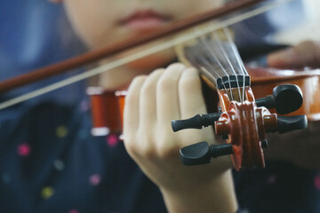 Close up hands of little girl on violin lesson in the room.	
