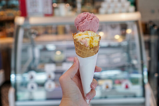 Two ice cream scoop with cone. A crispy waffle ice cream cone with strawberry and mango flavour.