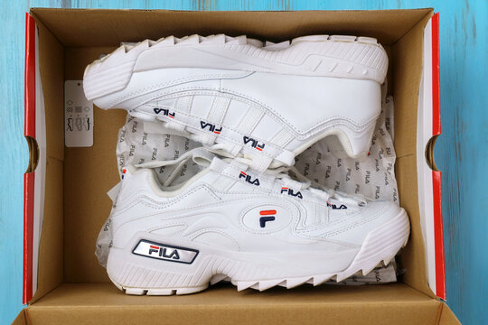 Tyumen, Russia-August 12, 2022: Fila white sneakers logo on clothes in a sports store. Sport and casual footwear concept