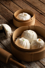 Chinese Steamed Buns and Dim sum, Asian foods in Bamboo Steamer Baskets on wood background Sa La Pao still life image baozi