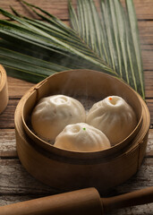 Chinese Steamed Buns and Dim sum, Asian foods in Bamboo Steamer Baskets on wood background Sa La Pao still life image baozi