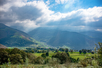 Cloudy sky and rays of light falling on the mountains of the valleys of Pas in Vega de Pas (Cantabria-Spain)