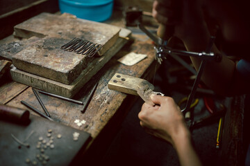 Jeweler at work in jewelry. Desktop for craft jewelry making with professional tools. Close up view...