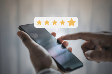 Business people using smartphone with popup five star icon for feedback review satisfaction service, Consumer online review or feedback for evaluate concepts