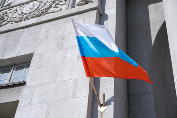Russian flag. Russian flag displayed on a pole in front house. National flag russian federation is waving up to the house hanging from a pole on the front door of the building.