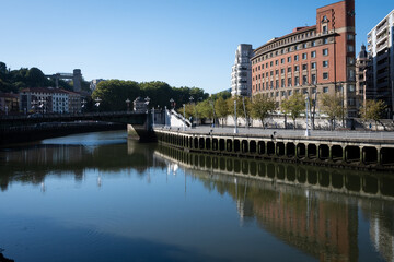 Naklejka premium A section of the Paseo de Uribitarte in Bilbao shot from the other side of the river Nervion on a sunny day