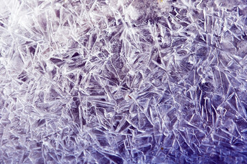 The texture of the ice surface. Winter background, festive background in the form of ice crystals, ice background for New Year's card, in purple tone.