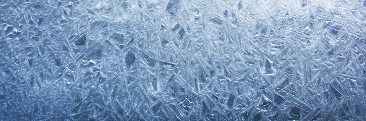The texture of the ice surface. Winter background, festive background in the form of ice crystals, in natural deep blue color.