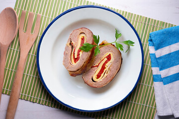 Roll of minced meat stuffed with red pepper, ham and cheese. Traditional Spanish recipe.