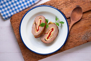 Roll of minced meat stuffed with red pepper, ham and cheese. Traditional Spanish recipe.