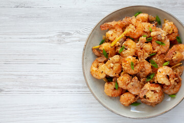 Homemade Crispy Salt and Pepper Shrimp with Scallions on a Plate, top view. Flat lay, overhead, from above. Space for text.