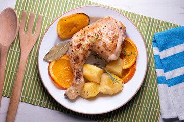 Baked chicken cooked with orange and potatoes. Traditional Spanish recipe.