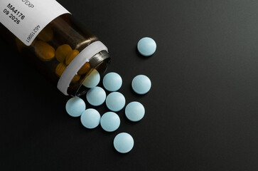 Fototapeta Butelka z rozsypanymi niebieskimi tabletkami leków obraz
