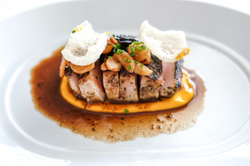 Close up of pork chop serve with on a white plate with sauce.