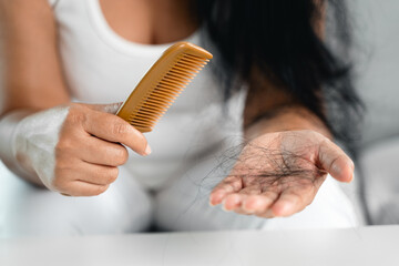 Hair fall problem. Asian woman with comb and hair problem. Hair loss from comb. Hair care and...