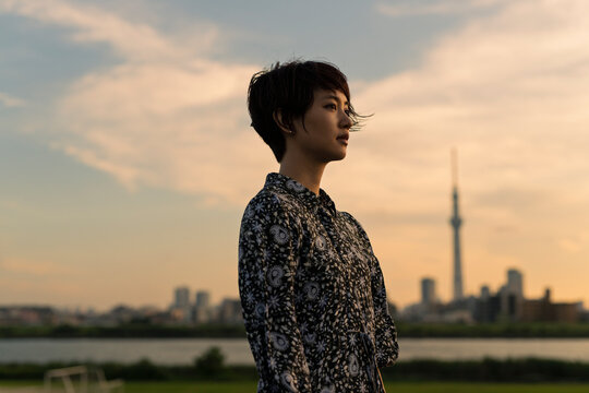 夕方 河川敷 ショートヘアの女性