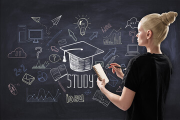 Back view of casual blonde woman with notepad and creative education sketch on chalkboard wall...