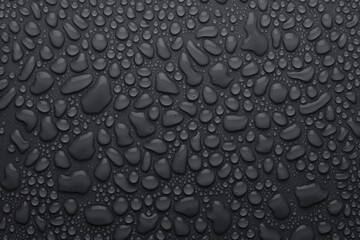 Water drops on dark grey background as elegant pattern with formless and round drops, top view.