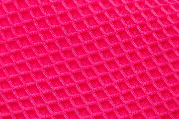 Red fabric texture. Close-up of an elastic scarlet nylon fabric with seamless pattern for sports...