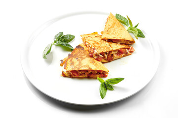Quesadilla with tomatoes and cheese in a white plate. Close-up, selective focus. White background.