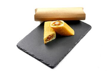 Sushi burrito with shrimp in maminori on blackboard. Close-up, selective focus. White background.