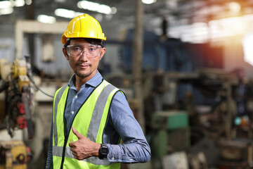 Technician engineer and worker in protective uniform standing with glasses and showing thumb up after controlling operation checking industry machine process at industry manufacturing