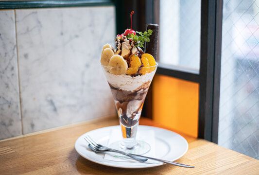 A luxurious parfait at the window in that caffe. 