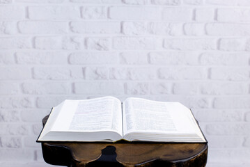 Bible on the table. On the background of a brick wall. Open Holy Bible