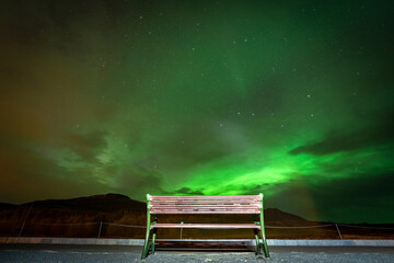 Bench with no people under northern lights