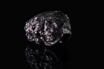 A piece of uncut black tektite with a rough surface