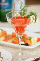 Red salmon caviar lies in a beautiful dish. Beautiful serving of food in a restaurant.