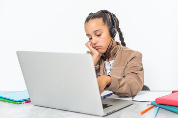 Distance learning online education. Photo of little upset and boring pupil. Little cute girl is bored and tired with doing her homework. New normal. Social distancing