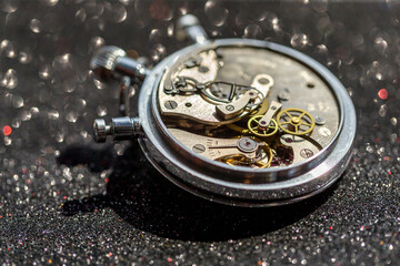 An old countdown timer opened up showing all the details of the mechanism on the black background, macro closeup