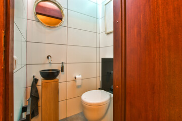Wall hung toilet and small sink in corner in lavatory room