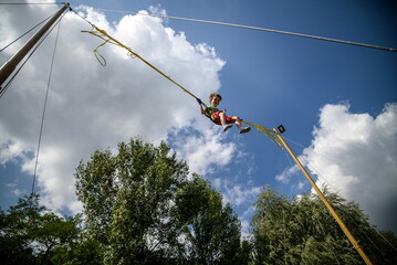 The boy is jumping on a bungee trampoline. A child with insuranc