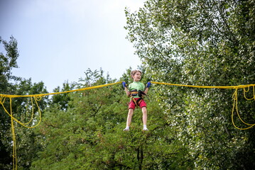 The boy is jumping on a bungee trampoline. A child with insuranc