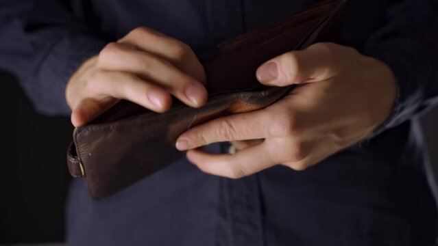 the man takes out his wallet. no money. empty wallet