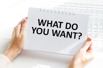 a man in the office holds a card with text WHAT DO YOU WANT . business concept