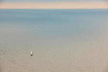 Sailboat crossing mediterranean sea at sunset. Infinite. Navigation and recreation