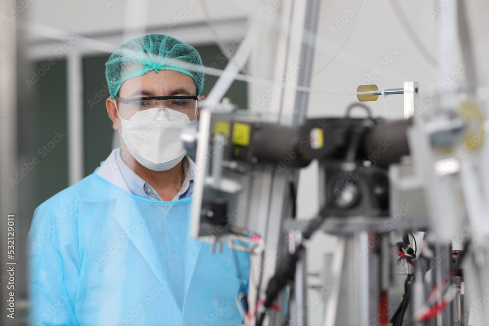 Poster worker in personal protective equipment or ppe inspecting quality of mask and medical face mask prod