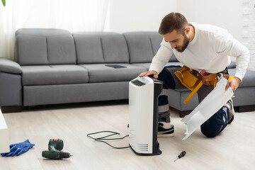 young man changing - fixing a dirty air purifier HEPA filter after using for a long time. A...