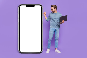 Photo of lucky excited guy dressed grey shirt rising fist typing modern gadget empty space isolated purple color background