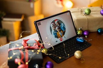 Big family singing christmas song at tablet camera during online video call. Smiling parents and children. Joyful family congratulating relatives with happy new year online