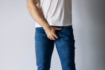 Obraz premium Man in white T-shirt wants to go to toilet. Problems with urology.