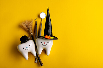 
dental concept. tooth figurine in halloween costume and dental tools. pumpkins and a broom. on a...