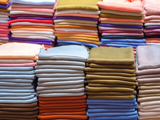 Pile of folded colorful textile. Heap of cloth fabrics. Arab textile production